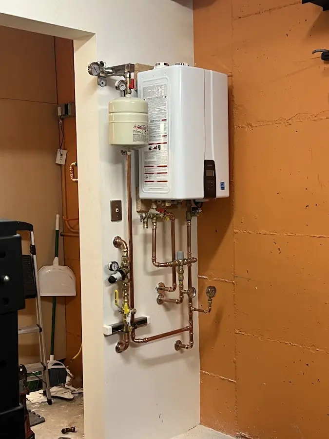 Plumbing technician inspecting water heater connections in Clearfield